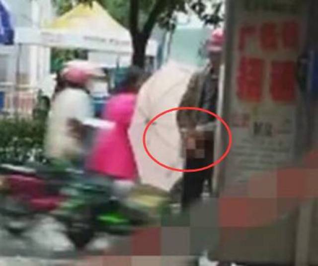 盐城一变态男在街上裸露下体,用手把玩,利用雨伞作掩护被拍_手机搜狐