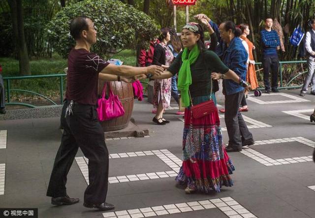 成都人民公園廣場舞大媽大爺開啟新技能,揹著孩子一起尬舞!