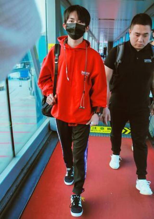 易烊千玺红衣红袜现身机场,没穿破洞裤没漏脚