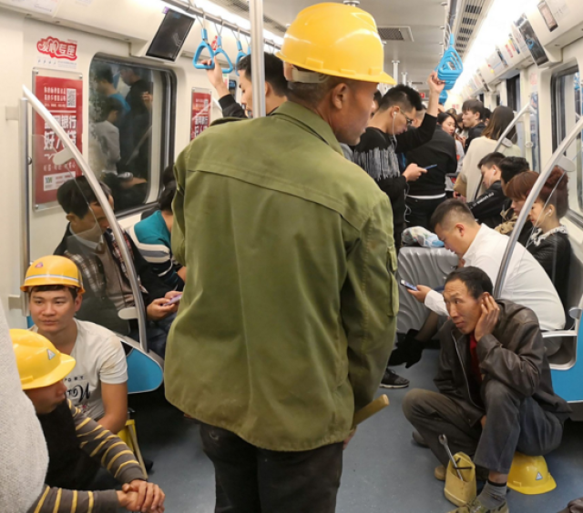 重庆农民工下班坐地铁1号线回家一身疲乏坐地上怕影响他人