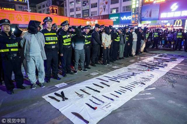 "黑社会"被抓街头示众 地上摆满枪支刀具