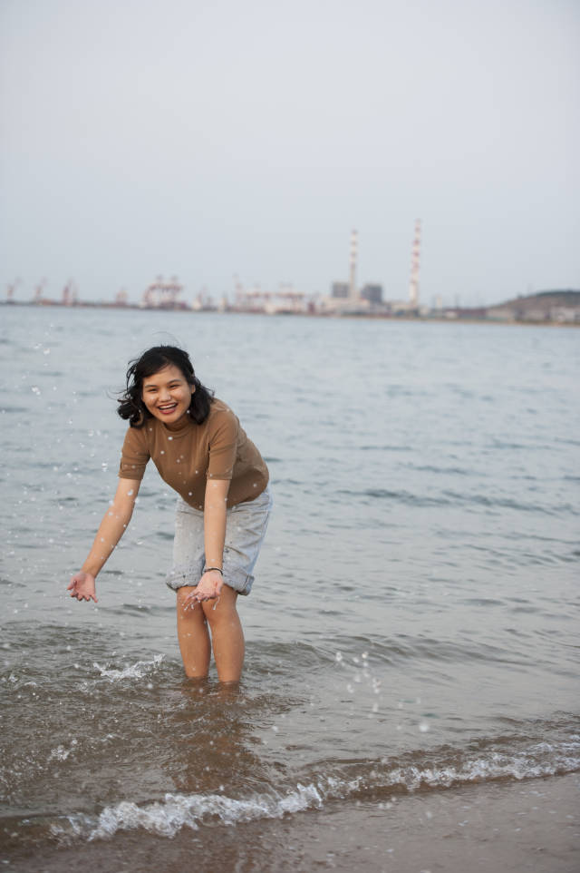 美丽的姑娘在威海的海滩上戏水秀美