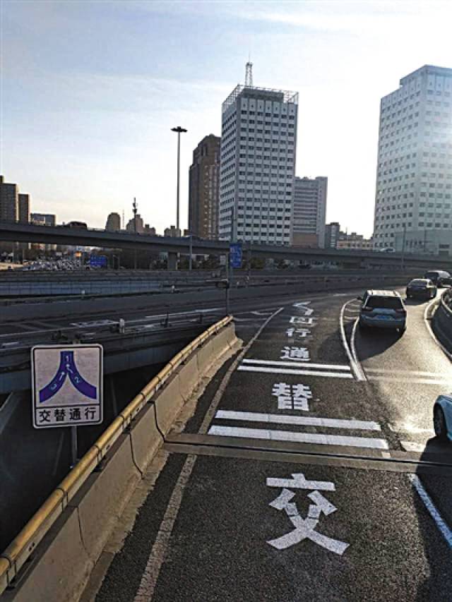 近日,西直门桥上增加了交替通行提示标志,并喷涂了地面文字标志.