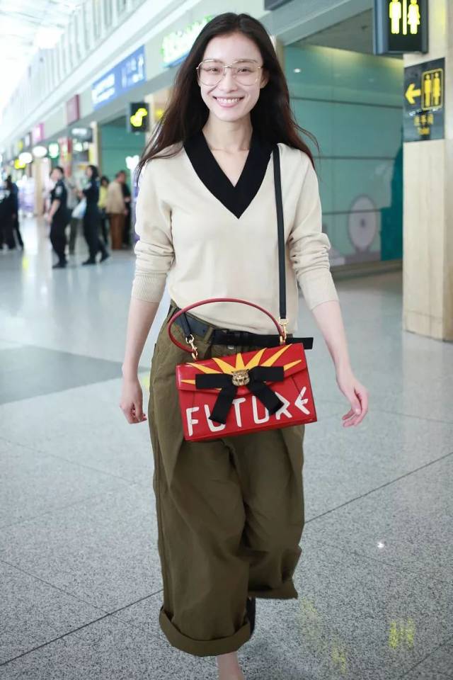 倪妮机场街拍时身着theory v领羊绒衫搭配yohji yamamoto芭蕾平惮鞋