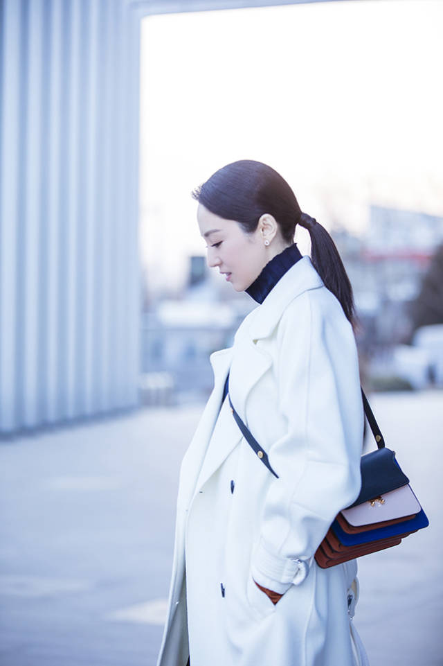 手捧咖啡的她斜跨起背包行走于楼宇间,低头浅笑沁人心扉,都市带感又