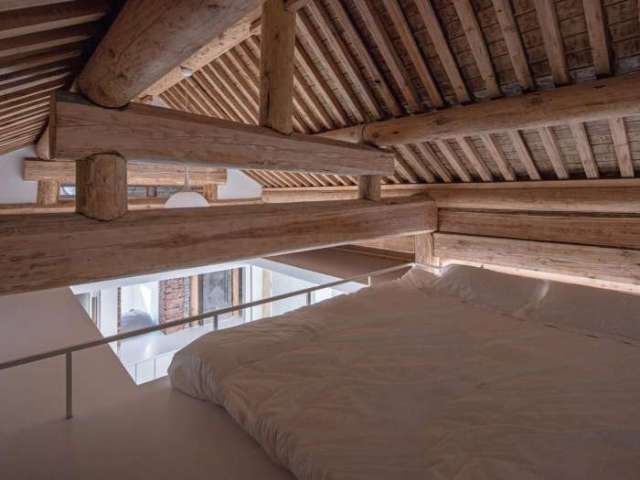 ▼旧有木质屋架恰好界定出相对私密的卧房区