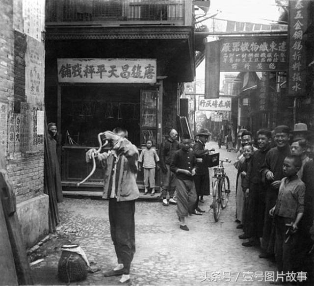 民国时期的上海,一名耍蛇人吸引了看热闹的人群