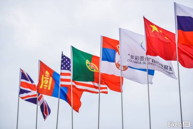 "多彩贵州"自行车联赛旗帜在各国国旗间迎风飘扬.