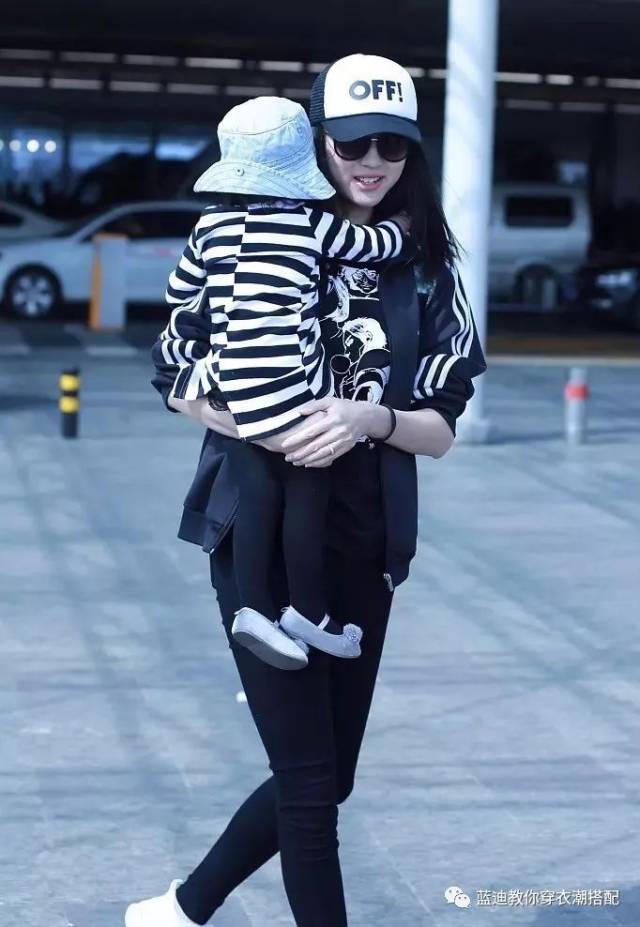 夹克内搭prada漫画t恤,脚踩reebok运动鞋,一身运动装扮辣妈范儿十足