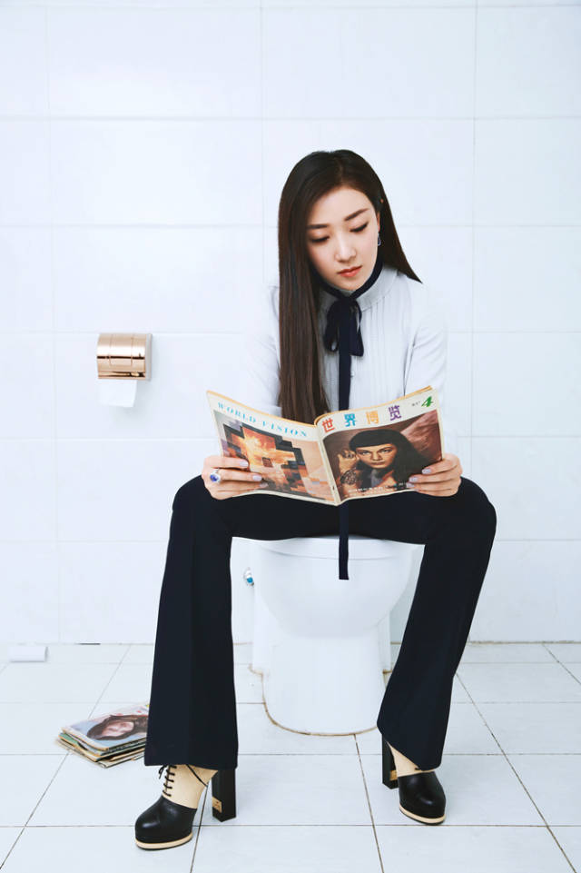 手拿复古刊物坐于马桶,或阅读,或凝思,一双长腿份外吸睛,自然随意间