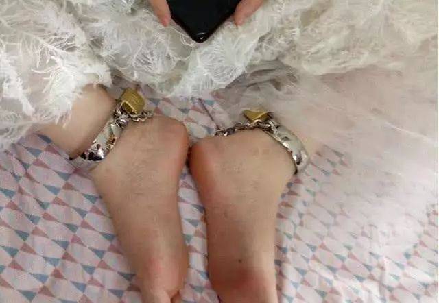 婚礼当天新娘穿着婚纱双脚被脚镣锁住脸上却洋溢着幸福的笑容