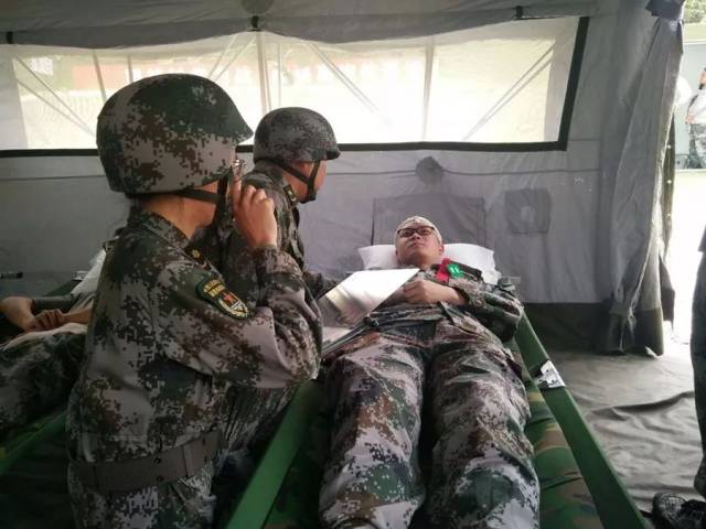 医疗队员对留治伤病员进行诊治.