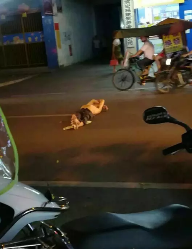 宜宾南溪南四中门口,一名男子晚上为何赤裸着上身躺在大街中间?
