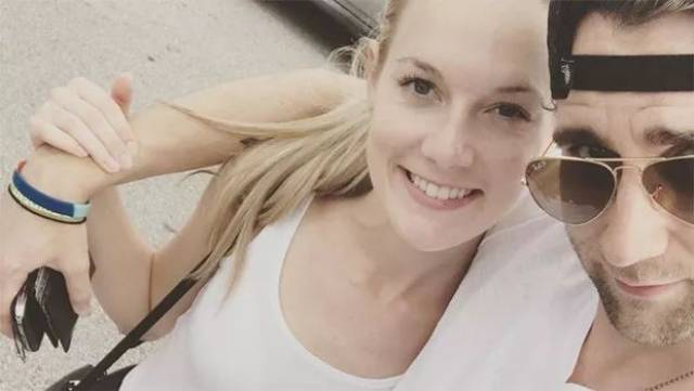 穿着西装的马修与穿白色婚纱,手捧白色鲜花的angela jones挽手同行