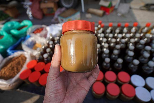 市场里一个卖香油,麻将的摊床前围了很多人,引起我们的兴趣.