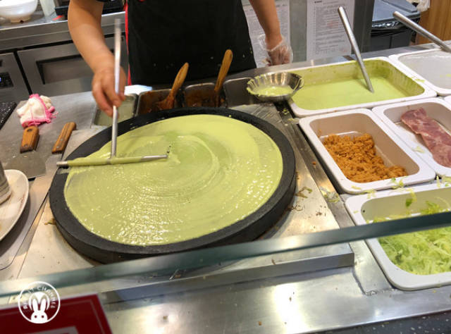 地下一层的煎饼果子摊位排着长长的队伍,两个阿姨一直在忙碌,一口气也