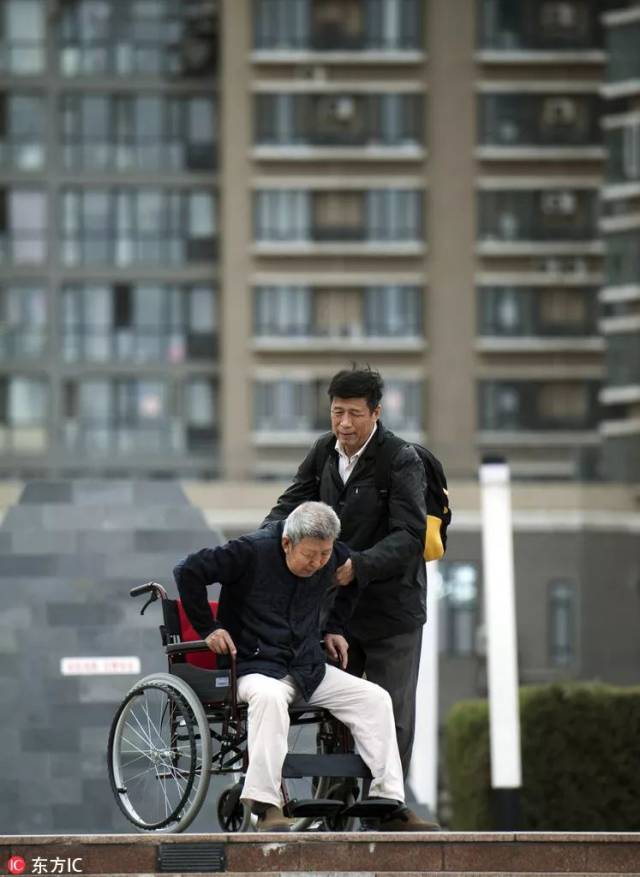 2016年4月2日,中国北京,一个60多岁的儿子推着轮椅,准备带他80多岁的