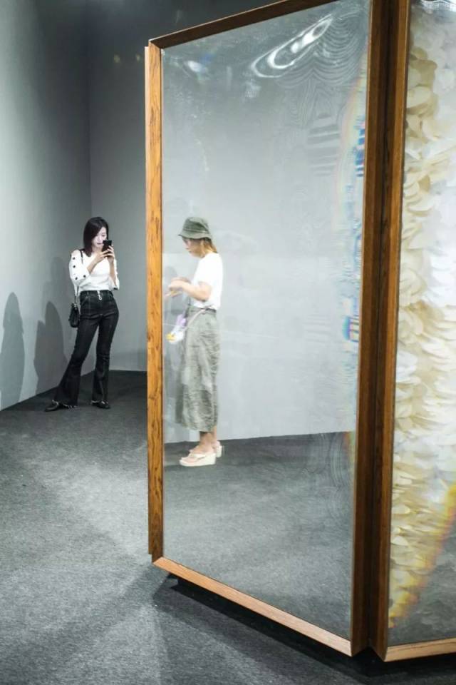内中是绚烂的图案 空间中部放置一个六边形的柱箱 和周边的镜箱形成一