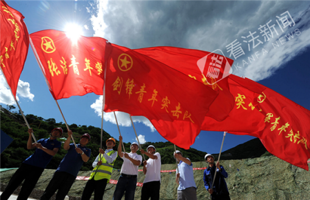 圖為青年突擊隊員們在位於延慶的國家高山滑雪中心建設工地揮舞隊旗