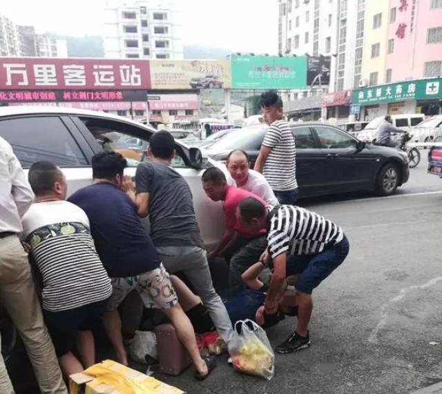 荆门万里客运站附近一女子被压车底,众人合力抬车救人!