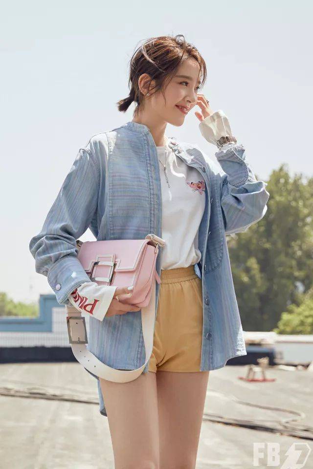 唐艺昕用粉蓝衬衫搭配白色内搭,黄色短裤和粉色包包,这身冰沙色穿搭