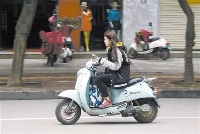 临海一妙龄女子骑电动车时玩手机,结果