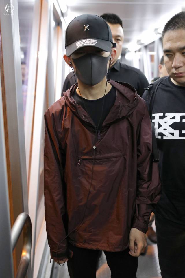 戴着口罩和帽子的易烊千玺面露微笑,但是却被身边的助理抢镜了