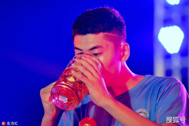 2018年7月26日,山东青岛金沙滩啤酒城,参赛选手在啤酒吹瓶比赛中.