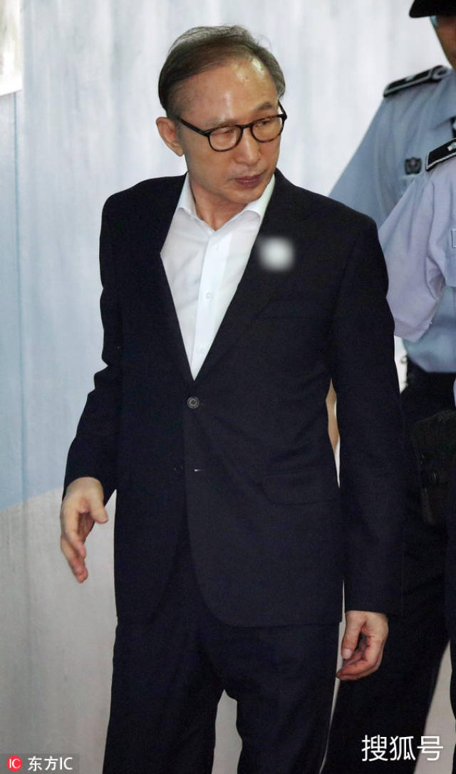 李明博再度出庭受审 单手系纽扣强打精神