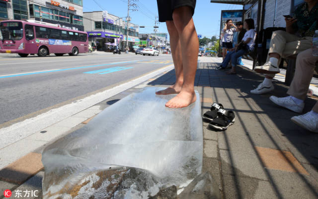 韩国高温持续热浪滚滚 民众花式消暑赤脚踩冰块