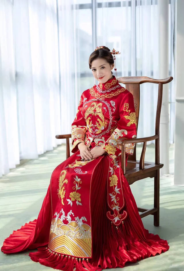 秀禾服一般是大裙摆,在接亲时,新娘可以坐在床沿,也可以盘坐在床中间