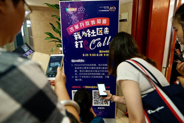 市民纷纷通过易拉宝上的二维码扫码参与答题