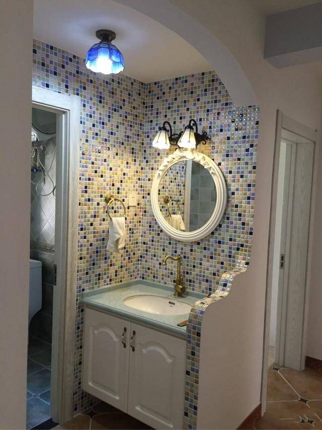 洗手池设计在卫生间外面,强上贴着马赛克墙砖,靠过道的墙造型很特别