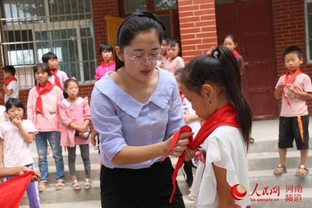 卞秀丽帮助学生系红领巾 孙俊旗 摄