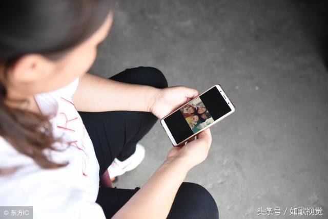 丁建桂翻看着手机里的照片,不禁泪水涟涟.