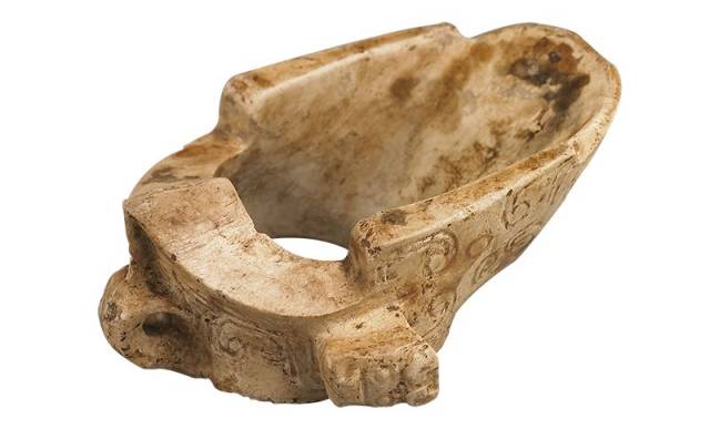 比商代妇好墓所出玉韘低矮,更接近环状,孔壁一侧呈坡状横向斜伸,与其