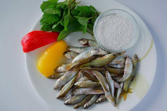 比较大条的鱼先入下,跟着其他也入锅,并以筷子撩动拨开不使沾黏