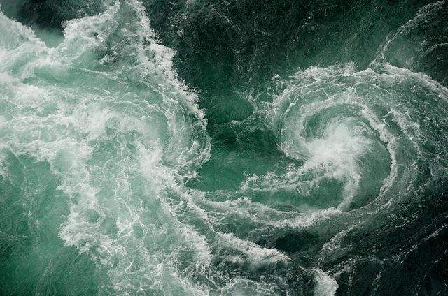 口想吞噬一切生命·一只小船在波浪中颠簸前行中年船夫撑着篙拍击波浪