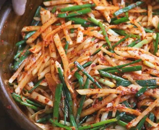 然后倒入60g左右的辣椒面用手拌匀腌制半小时