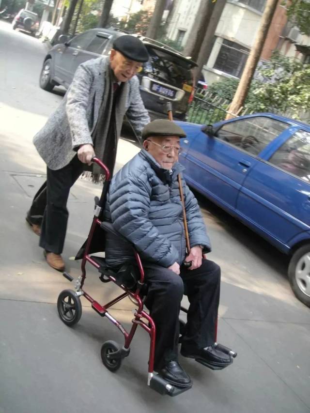 黄永玉推坐在轮椅上的黄裳前去吃饭.李辉 摄