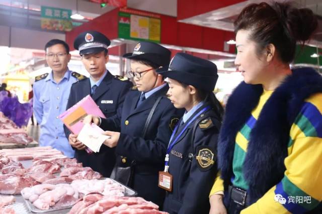 执法人员在农贸市场检查猪肉两证