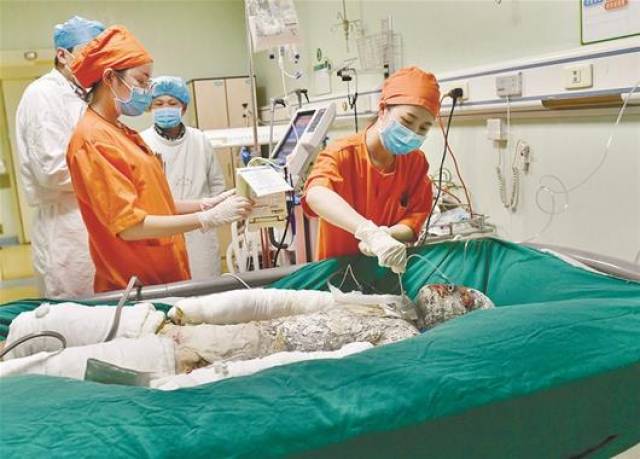 图为:昨日,严重烧伤的晓辉在武汉接受抢救