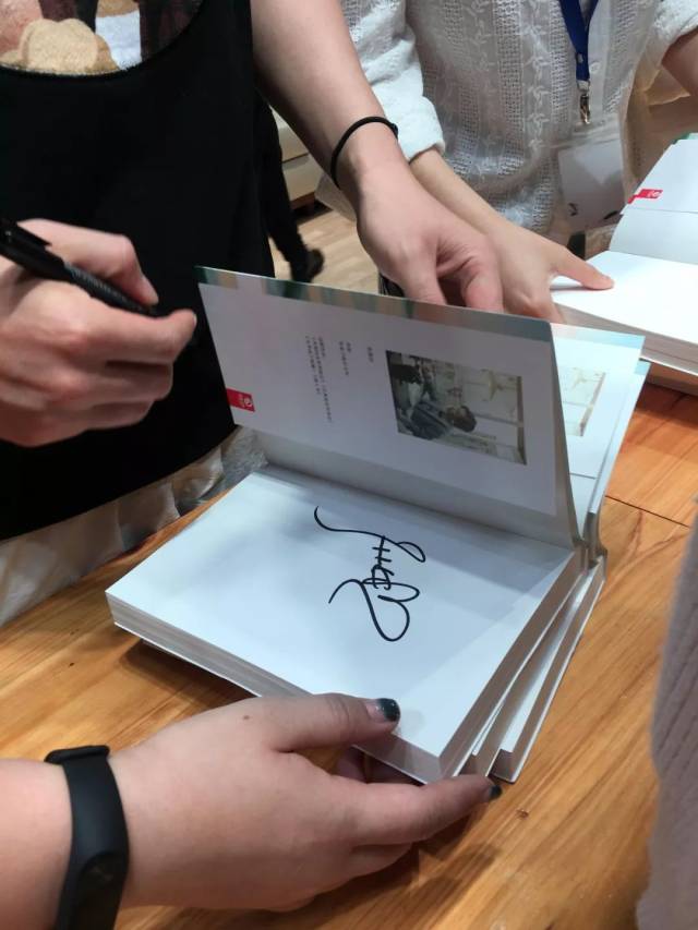 张嘉佳为同学们签名,在听到同学们表达对他的仰慕之情后,微笑示意,并