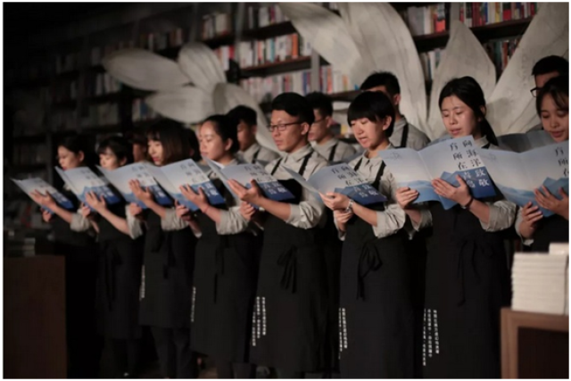 任夜向西倾 浅蓝色衬衣,墨绿色围裙是西西弗店员工装标配,与书店门头