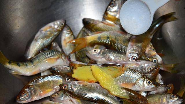 比较大条的鱼先入下,跟着其他也入锅,并以筷子撩动拨开不使沾黏