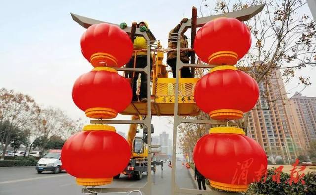 1月18日,渭南城区三贤路北段,工人师傅正在安装大红灯笼.