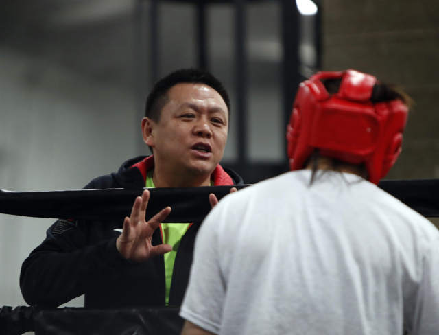 1月23日,中国女子拳击队教练王润强(左)在比赛间隙向队员布置战术.