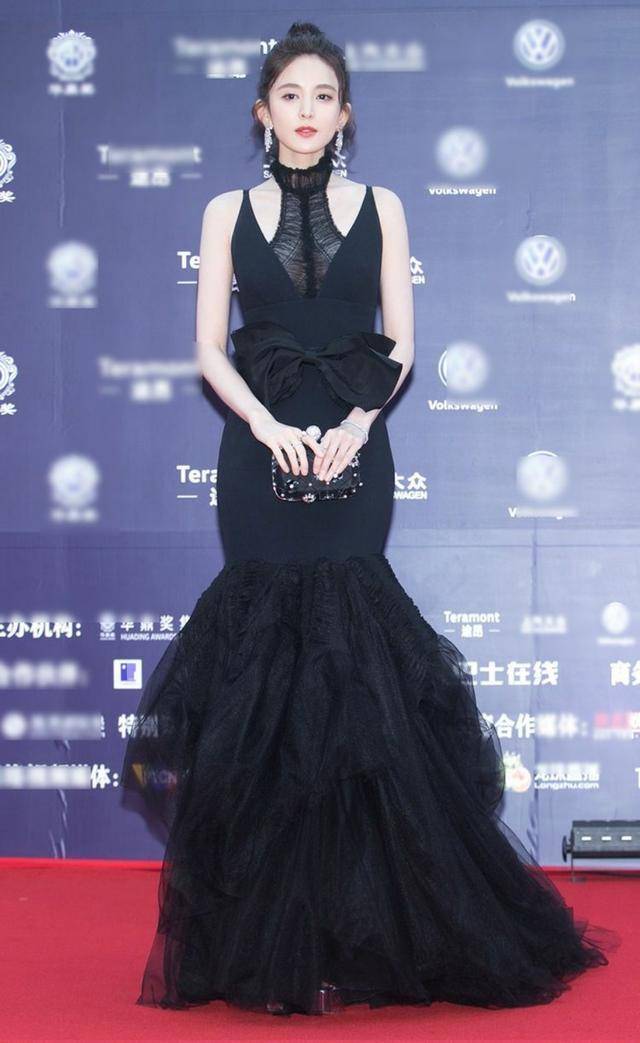 鱼尾裙,层层叠叠的裙摆更加温婉有魅力,手拿黑色小方包点缀,连发型都