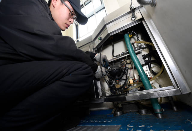 天津动车客车段库检车间甲班工作人员王浩然在检修列车厕所内的电路