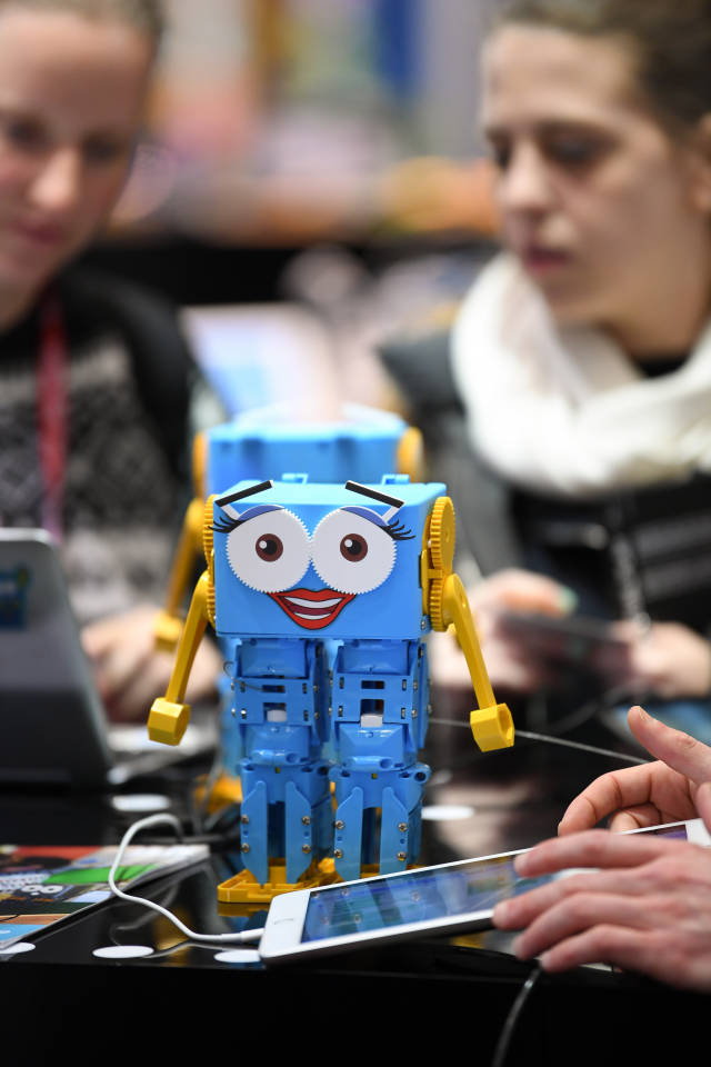 1月30日,在德国纽伦堡国际玩具展上,两名参观者观赏玩具机器人